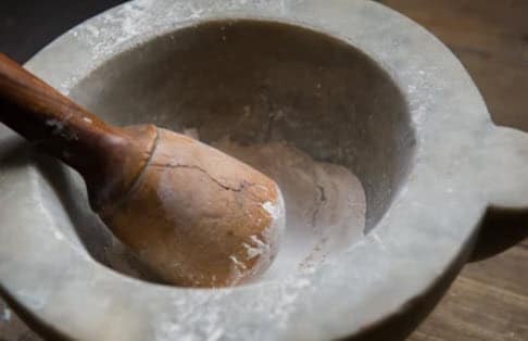 kava powder being made with a mortar and pestle